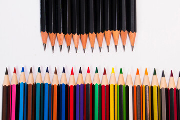 Naklejka premium Colored pencils lined up against drawing pencils