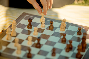 Game of chess. Family spending time in a summer park in nature on a sunny day. Board game, chess training