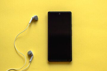 smartphone with blank screen and headphones, music concept