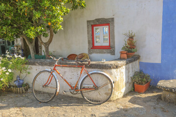 Bicicleta rustica contra parede em aldeia típica portuguesa.