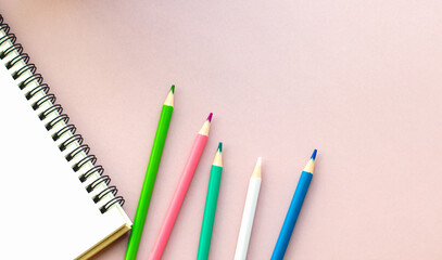  education, art, and office aesthetic concept. colored pencils, sketchbook on a plain pink background, copy space, web banner