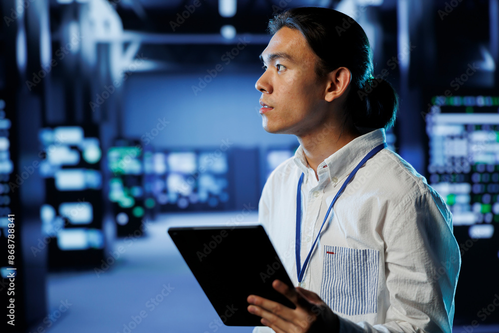 Poster it practitioner in data center uses tablet to prevent system overload during peak traffic periods. a