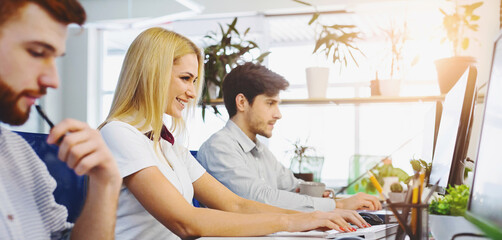 Obraz premium Working time. Diverse young people using office computers at coworking, empty space