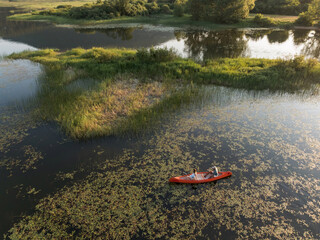 Young couple paddling a canoe on the beautiful calm lake, enjoying a fun adventure of canoeing...