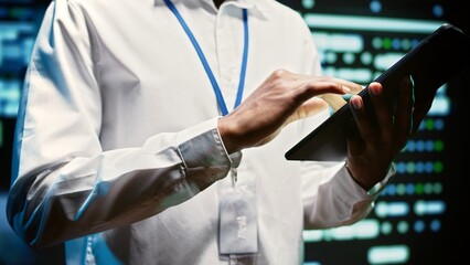 Admin in cloud computing business walking through server clusters used for computationally intensive tasks such as weather simulations. Supervisor doing yearly equipment inspection, close up