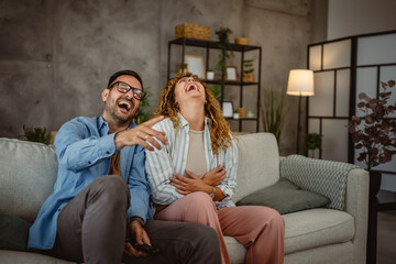 Obraz premium Adult couple boyfriend and girlfriend watch movie with popcorn at home
