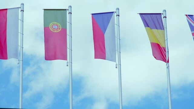 national flags Europe and other countries on satin flutter in wind in blue sky, European Space Agency, state symbols, concept of international cooperation, global business