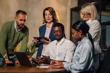 Interracial colleagues discussing project on a laptop at boardroom.
