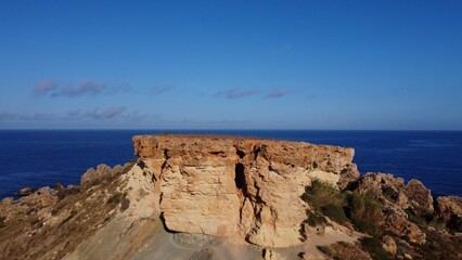Flat rock formation Qarraba peninsula, close up on the cracked limestone where climbers can climb on the top. Ghajn Tuffieha , Qarraba peninsula, aerial close up. High quality photo