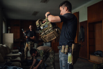 Group of airsoft players preparing for war game simulation indoors.