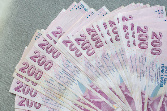 A thick stack of Turkish lira is laid out on a gray velvet table, ready to be counted, 200 Turkish lira bills, the currency for buying real estate,giving up cash and switching to non-cash payments