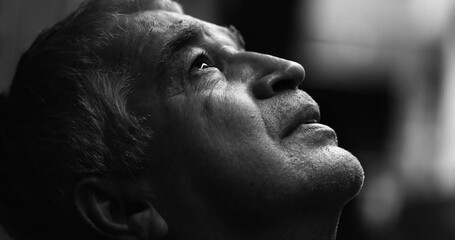Profile close-up face of spiritual senior man looking up at sky in quiet contemplation, dramatic black and white. Gray haired wrinkled face seeking help and SUPPORT