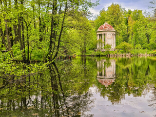 Obraz premium Small lake in autumn forest, reflection on water, under blue sky