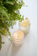 Enhance the ambiance with elegant candles and a fern arrangement for a calming atmosphere
