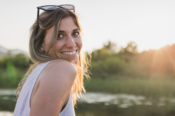 Portrait of a young woman relaxing in a canoe on a lake in nature