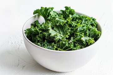 White bowl of kale chips with paprika on white background