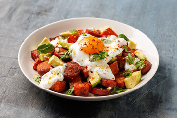 Sweet Potato and Chorizo Hash with egg, avocado and herbs.