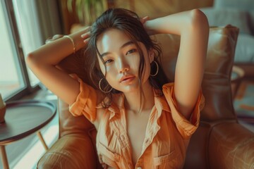 A woman sits in a chair with her hands pressed against her head, conveying a sense of frustration or worry