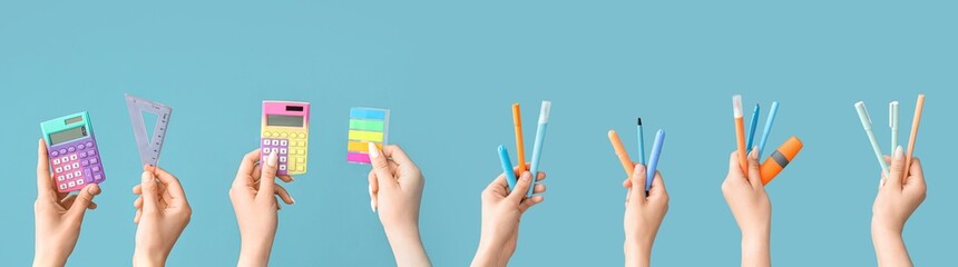 Many hands holding school supplies on light blue background
