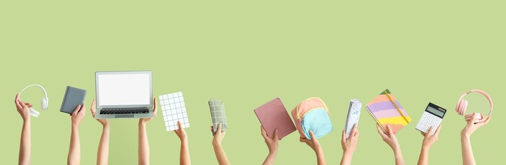 Many hands holding school supplies and laptop on color background