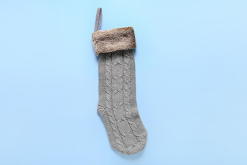 Christmas knitted sock on blue background