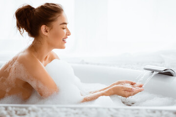 Pretty Woman Filling Bath With Water, Checking Temperature, Copy Space