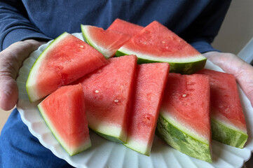 Man holds platter of watermelon slices closeup