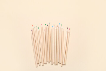 Set of color pencils on beige background