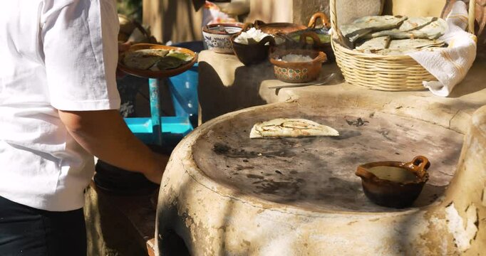 Traditional mexican food called memela being cooked with chef woman