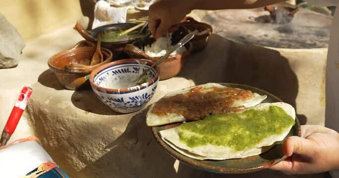 Point of view serving salsa over mexican food called memela