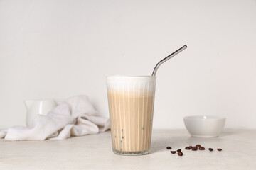 Glass of iced latte and coffee beans on white background