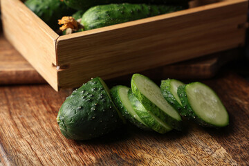 Cut fresh green cucumber on wooden background