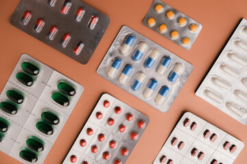 A collection of various blister packs of pills on a solid background for healthcare, medicine, or pharmaceuticals.