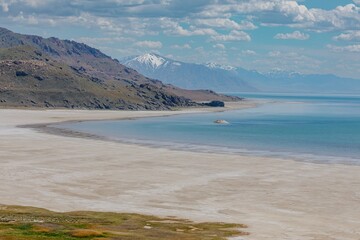 Fototapeta premium Beach shoreline and mountain range of The Great Salt Lake from Antelope Island, Syracuse, Utah, USA