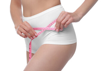 Diet and weight loss concept. Woman with measuring tape showing her slim body against white...