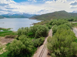 Country road, railway tracks and lake with mountain range in the distance. Midway, Utah, United...