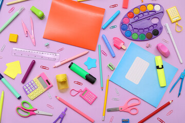 School supplies with copybooks, palette and calculator on lilac background. Top view