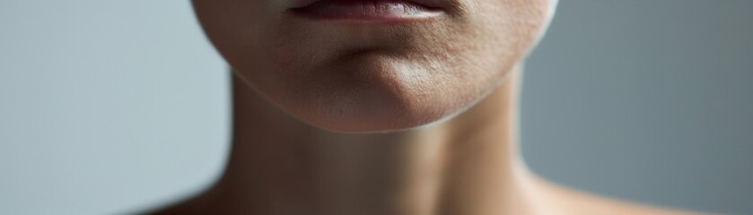 Fototapeta premium A close-up portrait of a person with a neutral expression, on a simple gray backdrop