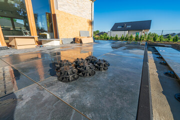 Ceramic terrace tiles on adjustable supports under construction. Elevated exterior floor build...