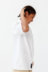 Youthful boy styling his hair with confidence against a clean white background