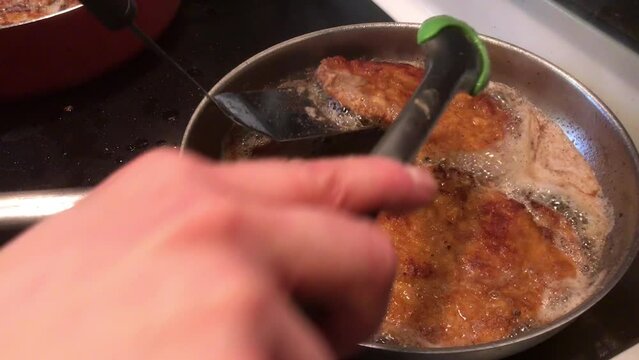 Schnitzel cooked in grease on stove for a home meal
