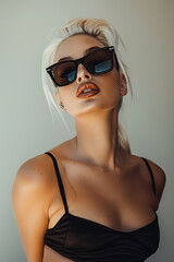 Fototapeta premium Chic Woman in Black Sunglasses and Bikini Against Soft Background