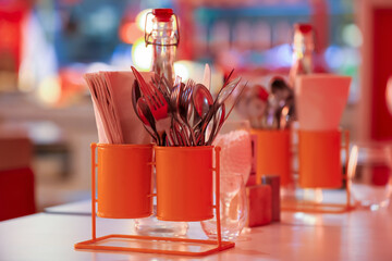 Close up view of table top stand with cutlery and napkins.