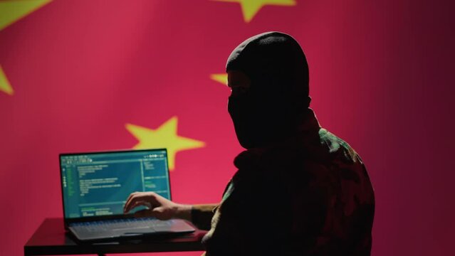 China secret police agent using mass propaganda tools on laptop to influence population minds, engaging in psychological operations. Chinese spy committing PsyOp warfare using notebook, camera A