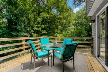 Wooden Deck With Teal Furniture Surrounded By Lush Green Trees