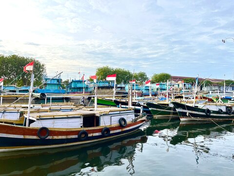 Several traditional wooden fishing and passengers boats with Indonesian Flag moored in Probolinggo fishing port