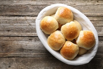 Delicious dough balls in basket on wooden table, top view. Space for text