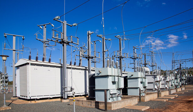 Electrical substations, Pylons and wires distribute power through high-voltage transmission lines. Blue Sky. Queensland, Australia.