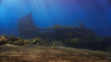 Underwater photo of the Japanese wreck in rays of sunlight. Shipwrecki from World War Two. From a scuba dive in Bali, Indonesia, Asia.