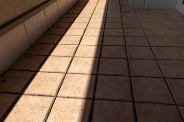 太陽の光が差し込むタイル敷きのベランダ